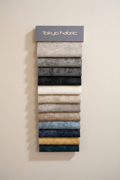 Fabric swatch sample card with Tokyo Fabric branding on a textured wall background